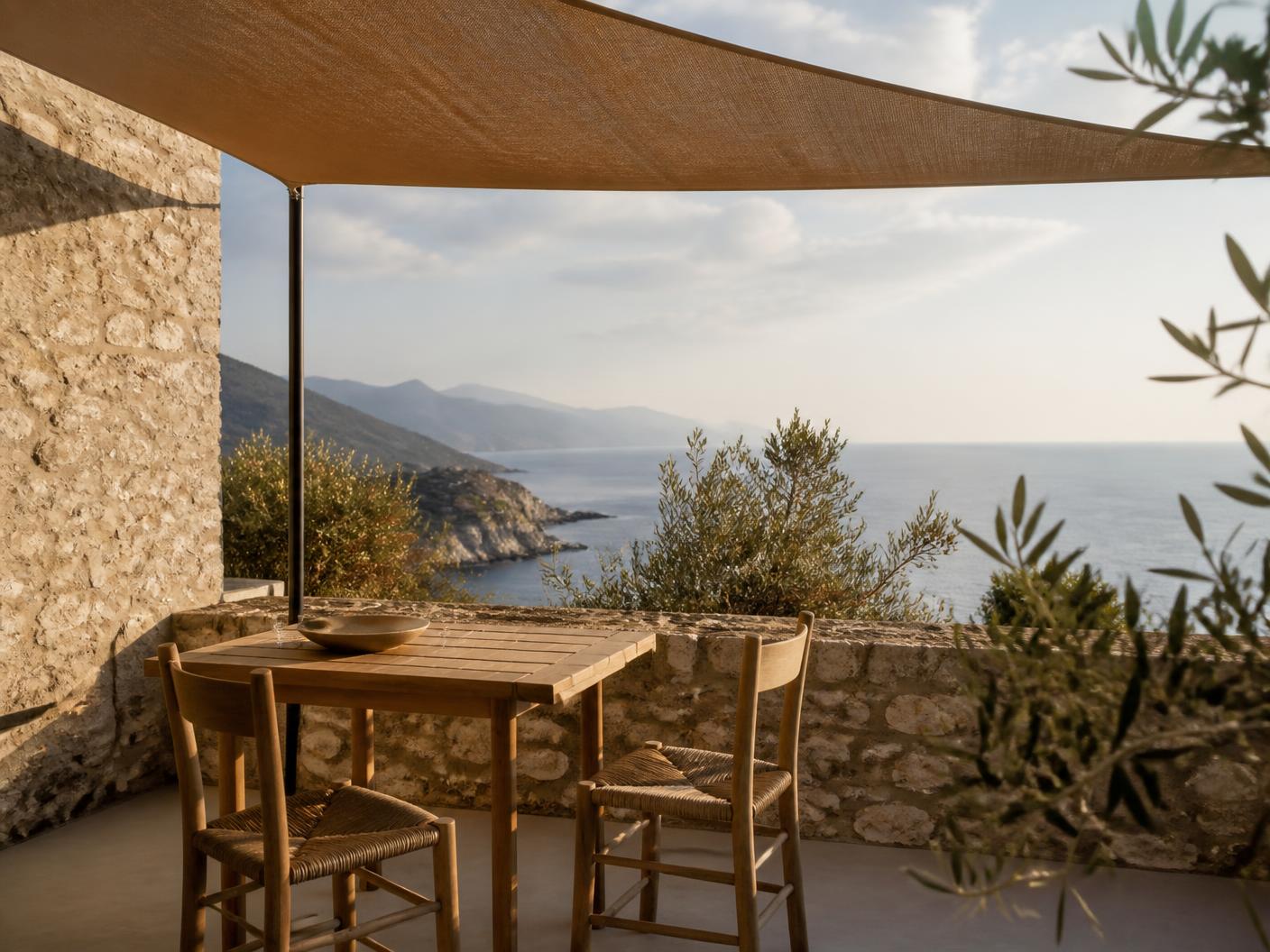 Terrace table for two under linen shade overlooking the coastline